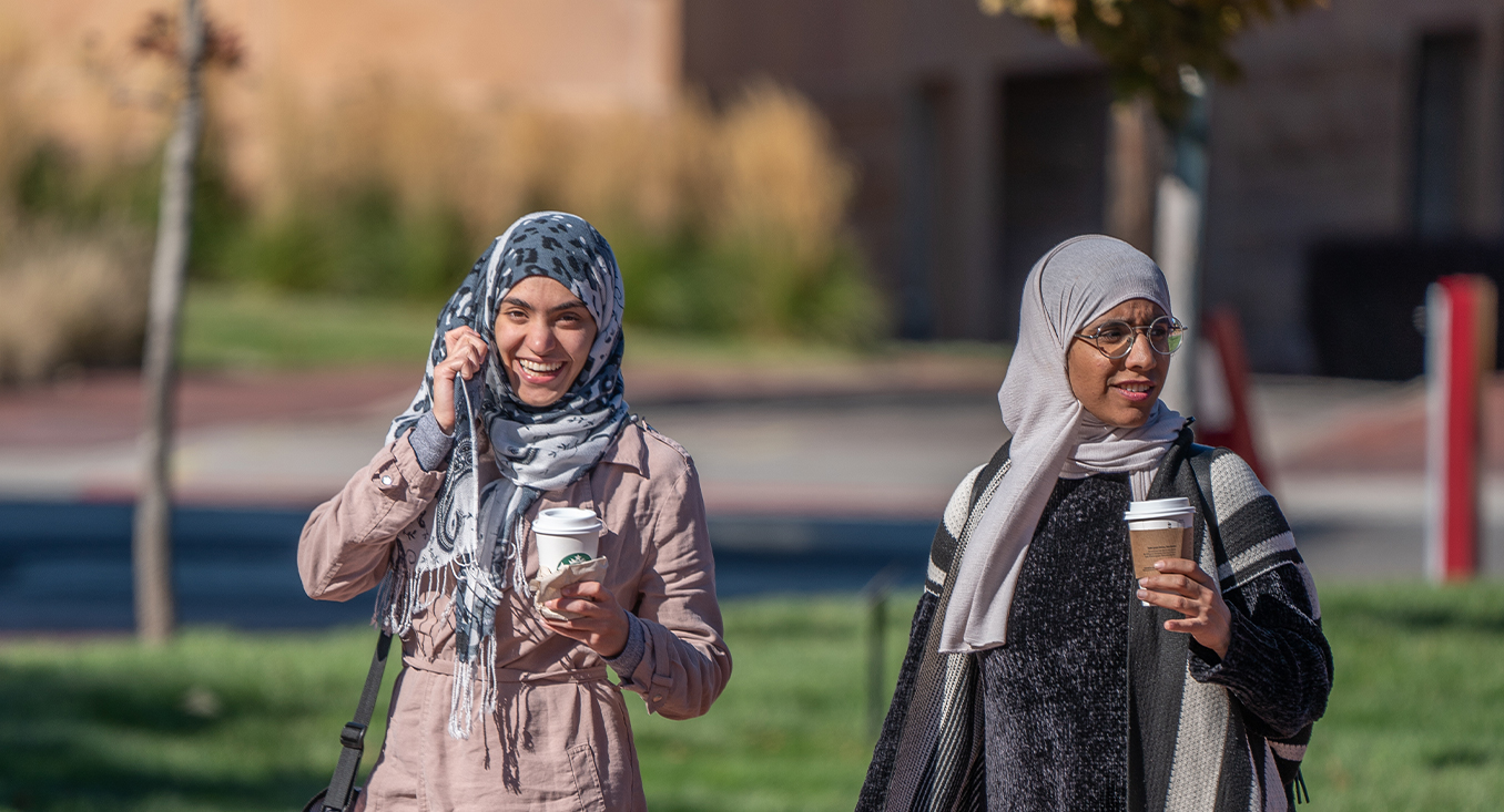 two women with head scarves walking on campus