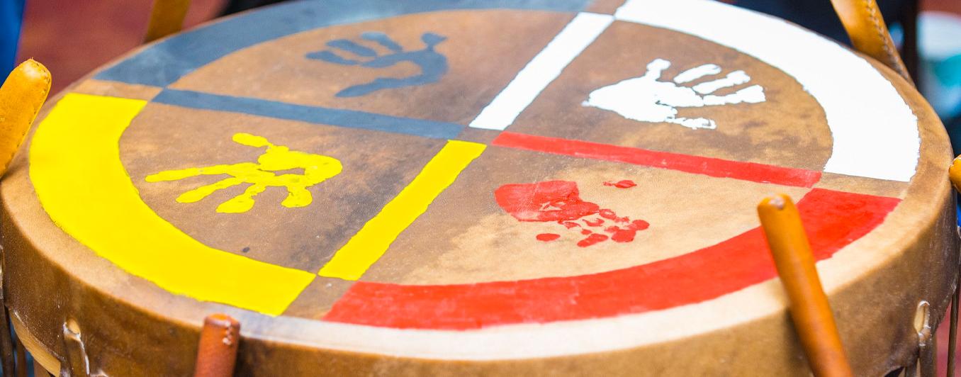 drum surface painted with primary colors and small hand prints