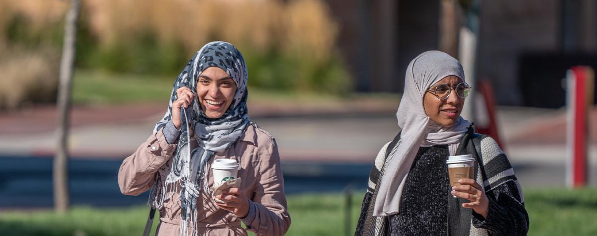 two women in headscarves walking on campus